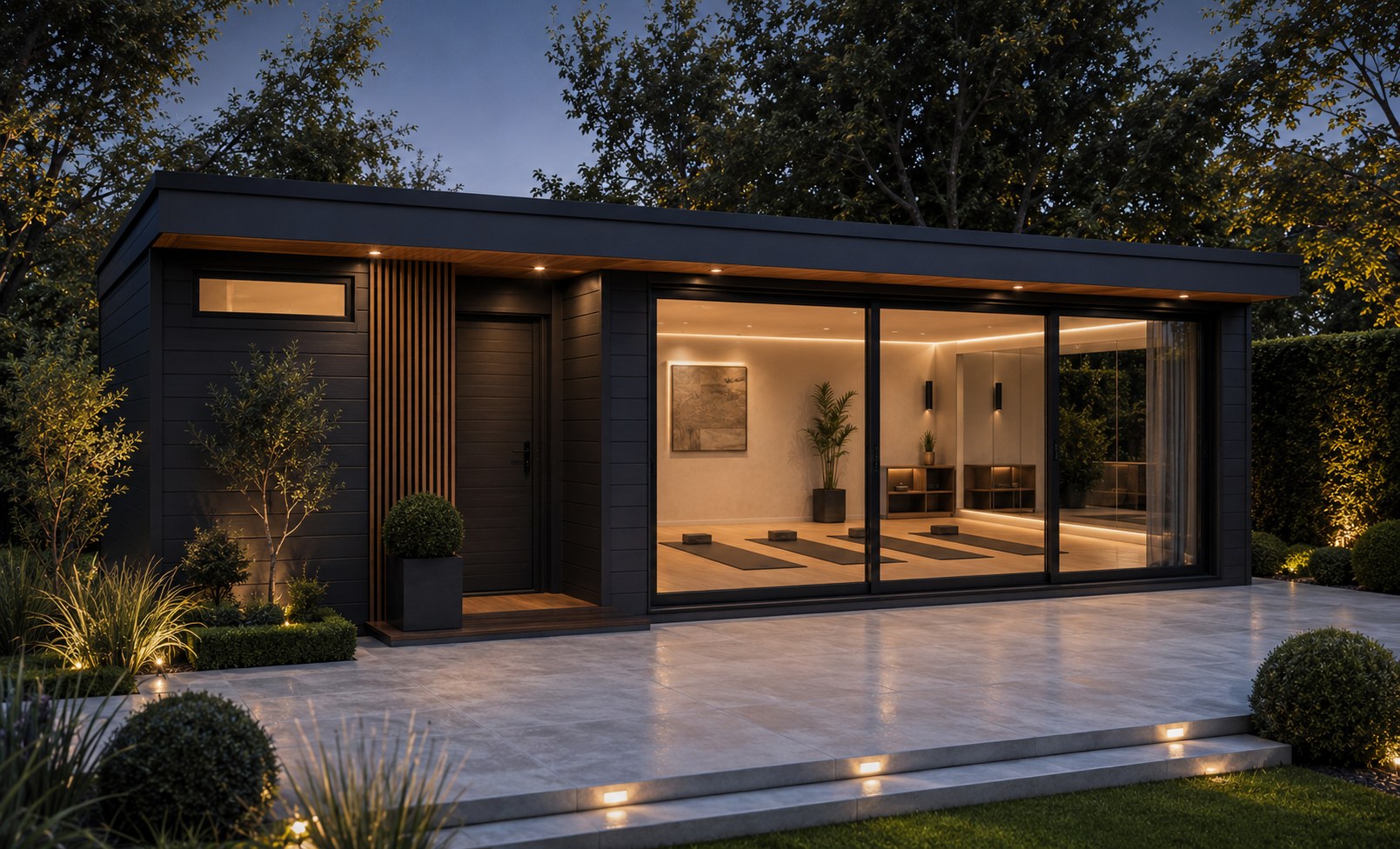 Signature wellness garden room at dusk with lit yoga studio behind full-height sliding glazing